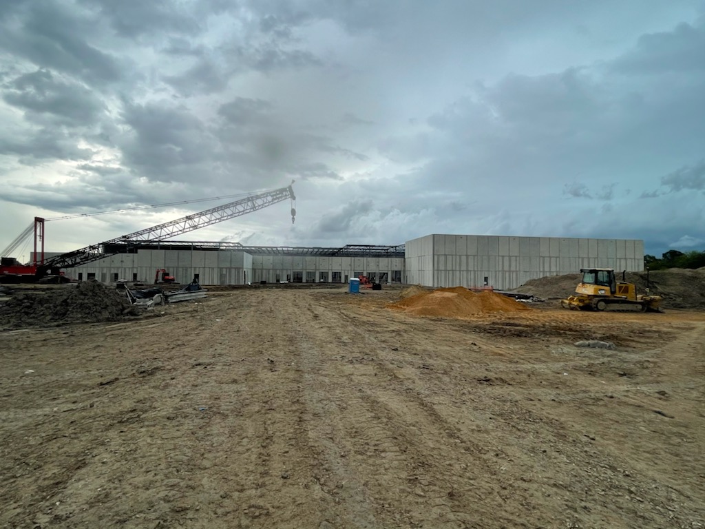 Tilt wall warehouse construction with crane and bulldozer on active site at FujiFilm Nexus Warehouse