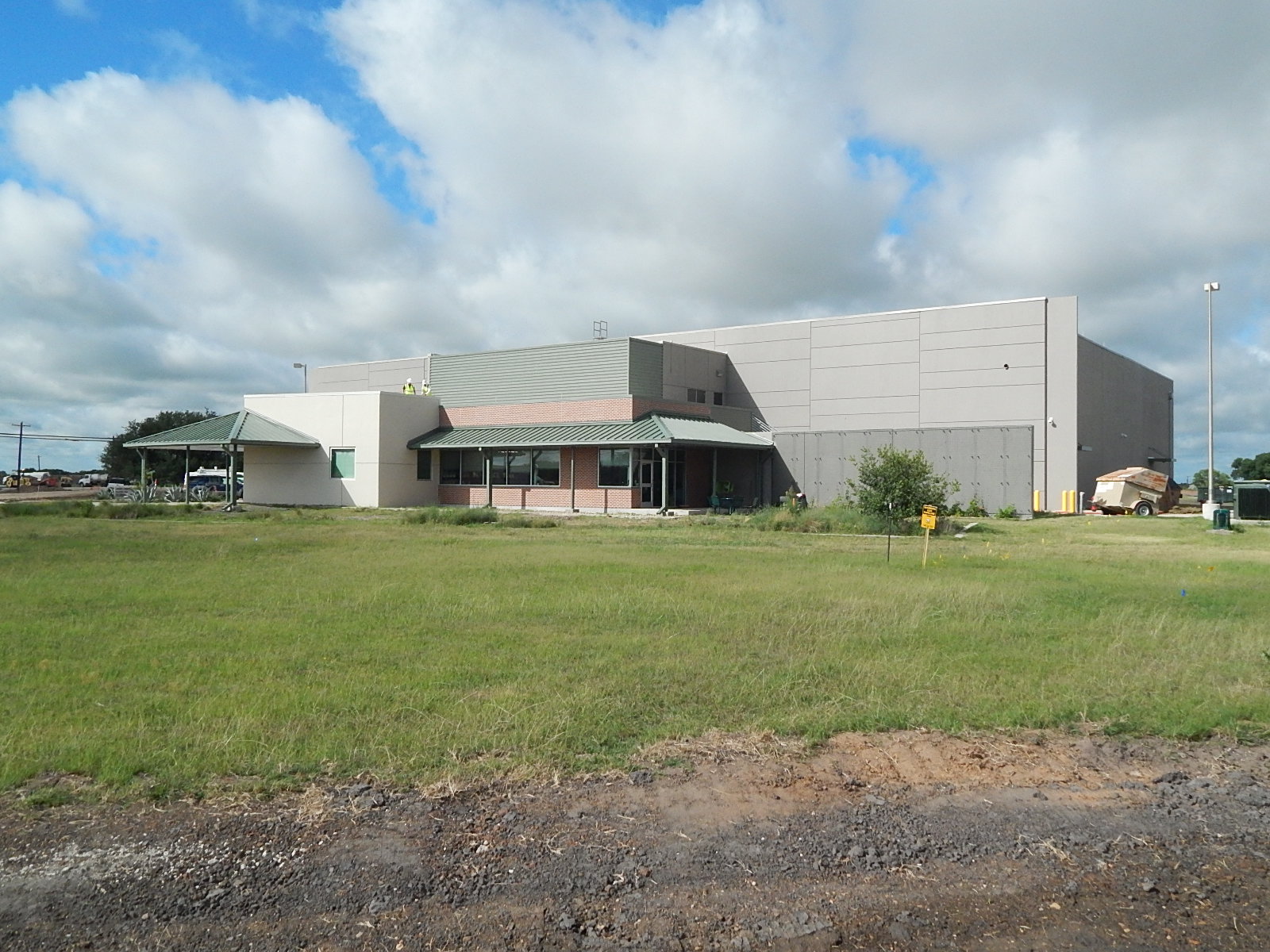 TAMUS Joint Library building exterior showing brick office wing and tilt wall warehouse section during construction